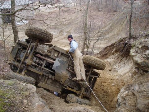1992 Ford Bronco - Vehicle stuck and overturned in a muddy off-road terrain.