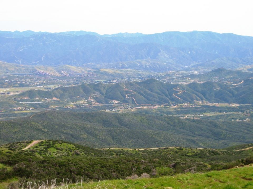 Hazy mountain landscape with green hills and distant valley development