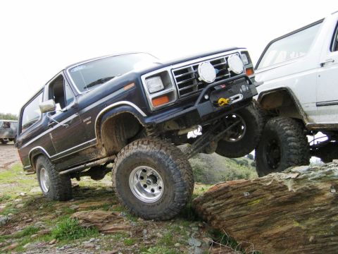 1985 Ford Bronco - A 1985 Ford Bronco navigates a rocky trail, demonstrating its off-road capabilities.