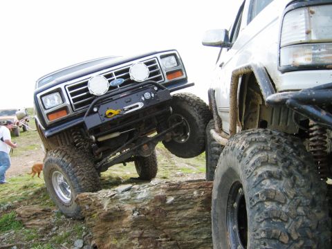 1985 Ford Bronco - Two off-road vehicles navigate a challenging rocky terrain.