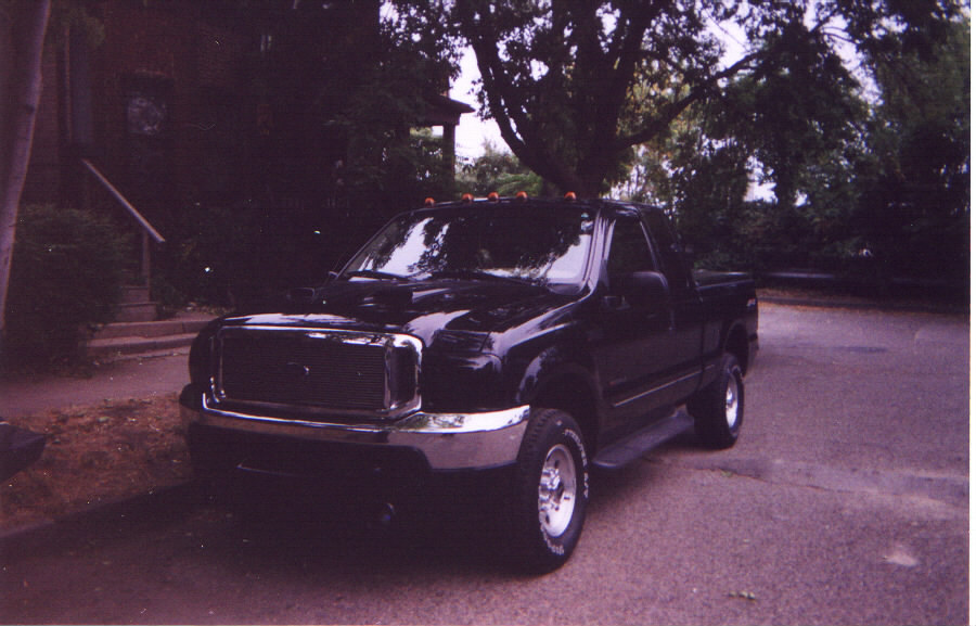 1999 Ford F-250 pickup truck parked on street in front of a house