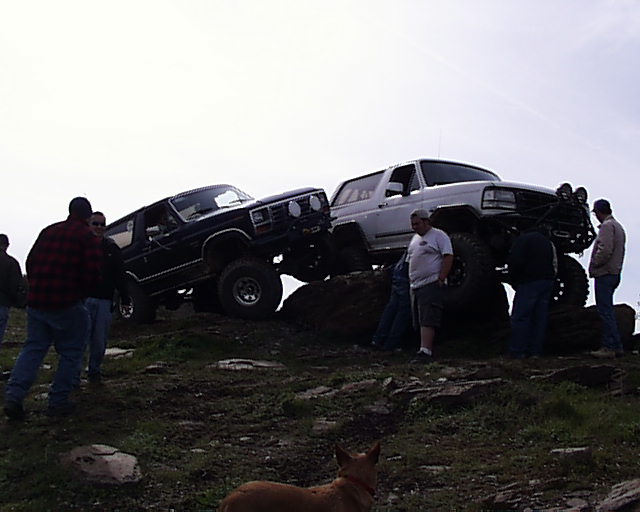 1993 Ford Bronco and another lifted Bronco on rocky terrain with people around