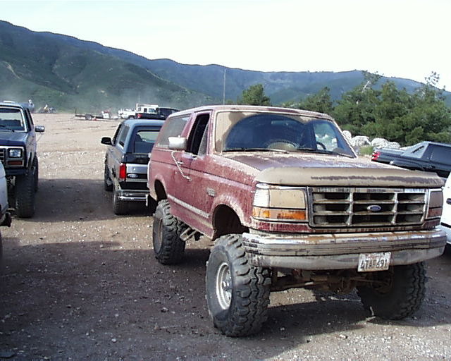 1993 Ford Bronco front end with large tires and a dusty finish