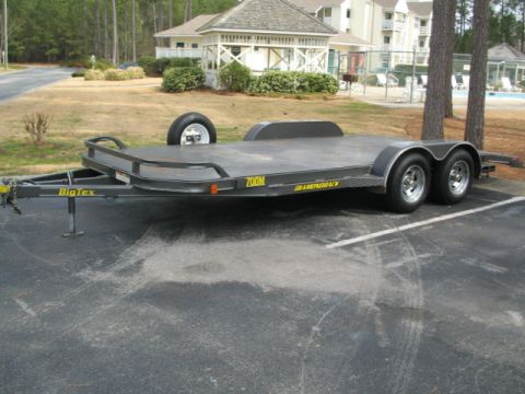 1996 Ford Bronco - A Big Tex car hauler trailer is parked on asphalt, with buildings and trees in the background.