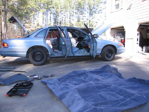 1991 Ford LTD Crown Victoria - A light blue 1991 Ford Crown Victoria LTD is parked outside a garage with its doors and hood open, suggesting interior work is in progress.