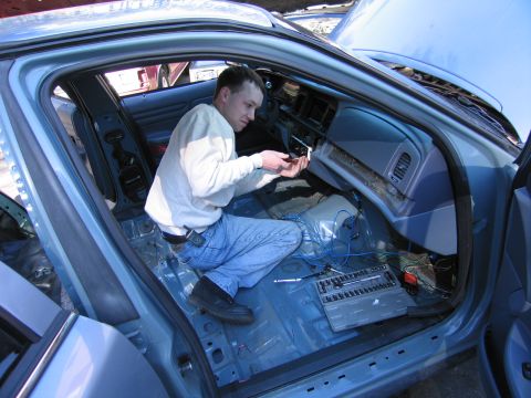 1991 Ford LTD Crown Victoria - A person is working on the interior of a car, with the dashboard disassembled and tools laid out.