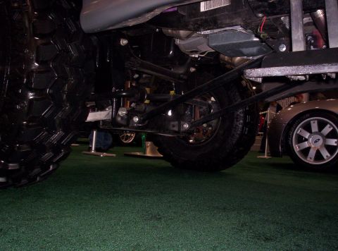 1989 Ford Bronco - A low-angle view of a vehicle's undercarriage, with another car visible in the background.