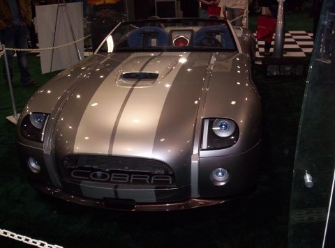 1989 Ford Bronco - A silver convertible with racing stripes is displayed, 'COBRA' lettering on its front grille.