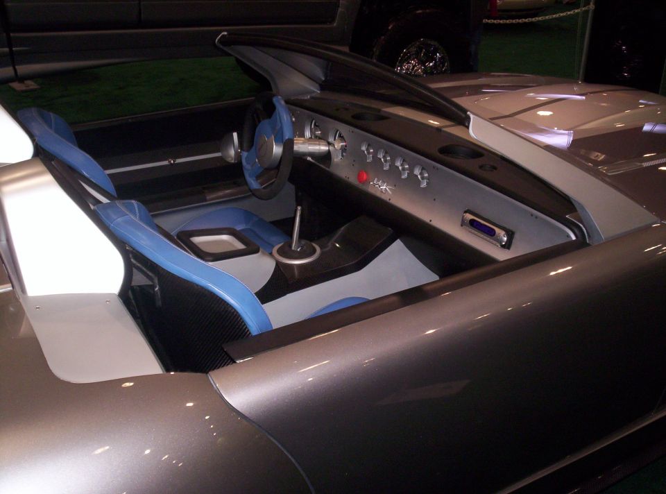 Car interior with blue and black seats, silver dashboard, and blue steering wheel