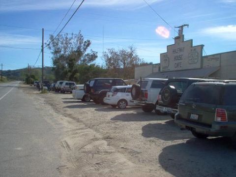 1988 Ford Bronco - A row of vehicles are parked outside the Halfway House Cafe on a sunny day.