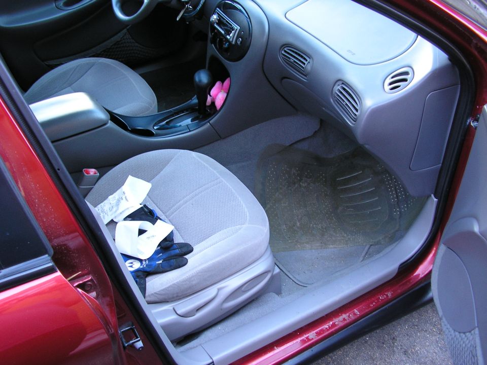 Interior of a 1998 Ford Taurus showing the passenger seat and dashboard