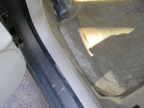 1998 Ford Taurus - The interior door sill and floor mat are visible, along with a pedal labeled "PUSH TO RELEASE".
