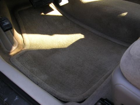 1998 Ford Taurus - Tan carpet floor mats are visible in the driver's side footwell.