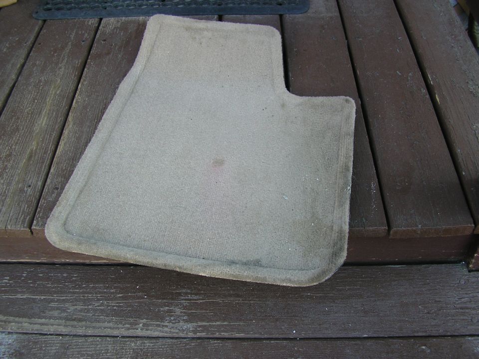 tan car floor mat on wooden planks