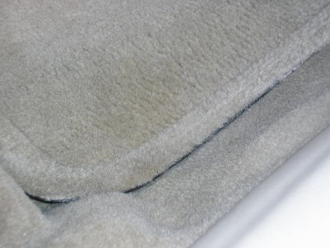 1998 Ford Taurus - Close-up of a gray carpeted floor mat with black trim, likely from a vehicle interior.
