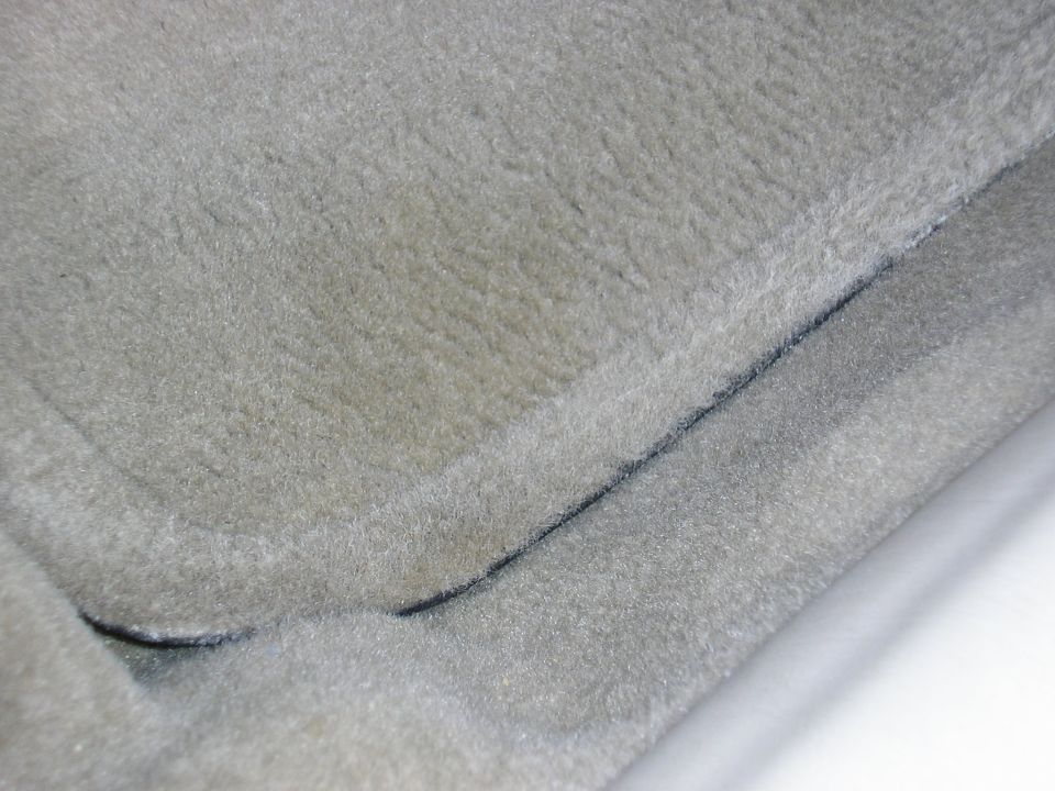 Gray carpeted floor mat with black trim