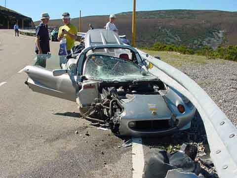 1993 Ford Bronco - Silver sports car sustained significant damage after colliding with a guardrail on a roadside.