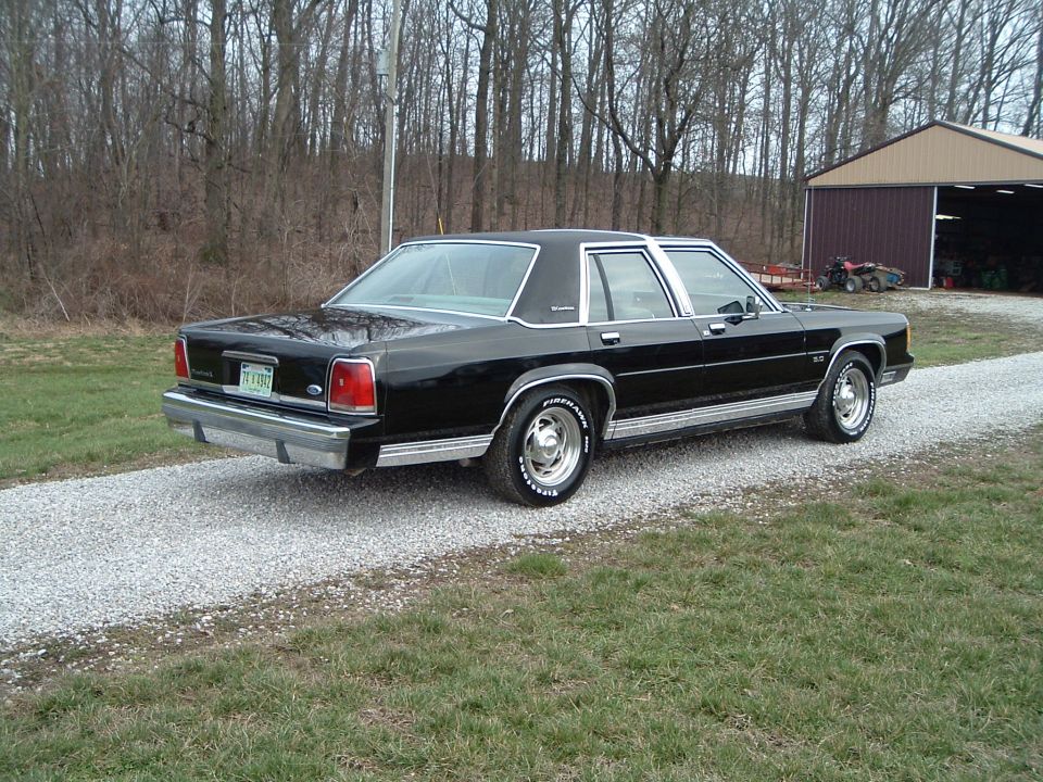 1989 Ford Crown Victoria LTD parked on gravel, rear view. Chrome trim and wheels