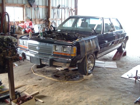 1989 Ford Crown Victoria LTD - Ford Crown Victoria in a garage with the engine removed and hood open.