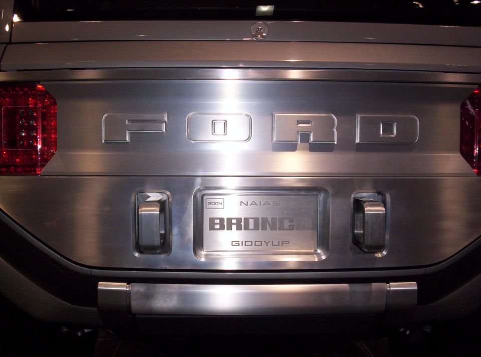 Back of a Ford Bronco with 'BRONCO' and 'Giddyup' on the tailgate. Also shows '2004 NAIAS' badge