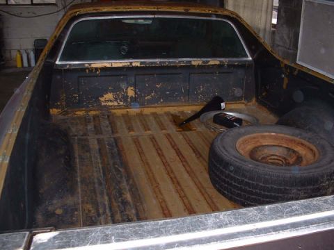 1972 Ford Ranchero - Interior of a 1972 Ford Ranchero pickup truck bed, showing a spare tire and some tools.