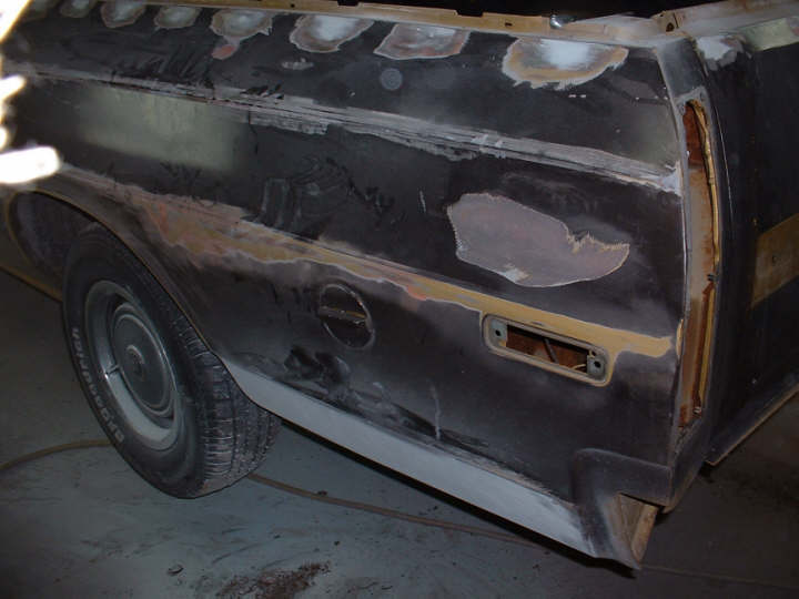 1972 Ford Ranchero side panel with primer and body filler, showing a fuel door and taillight housing