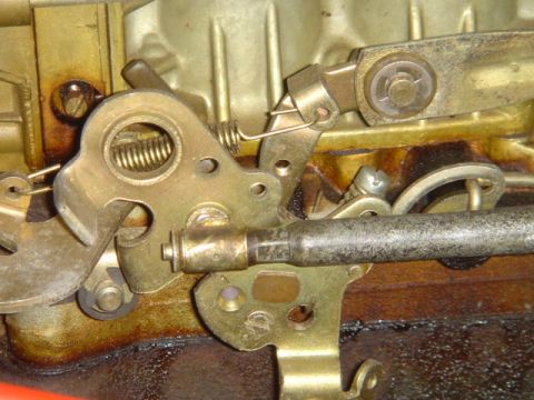 1975 Ford Ranchero - Close-up of a carburetor's mechanical linkage, highlighting the intricate assembly of levers and springs.