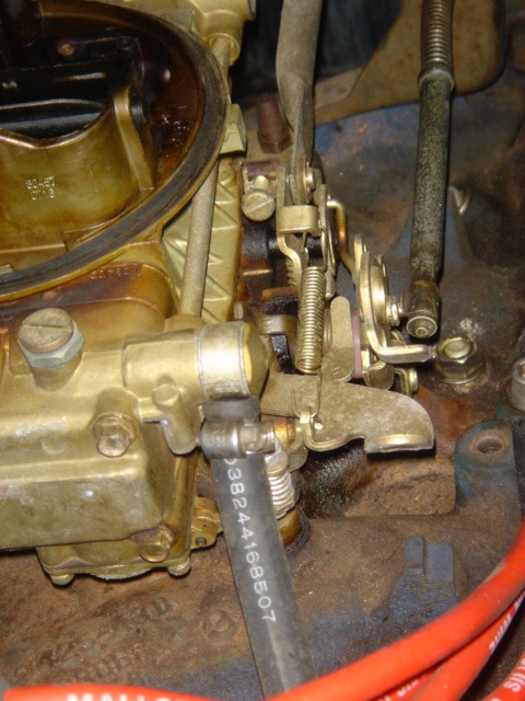 1975 Ford Ranchero - Close-up of engine carburetor linkage and a fuel hose with part numbers visible.