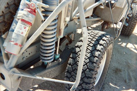 1990 Ford Bronco - coilover shock, suspension arms and a chunky off-road tire are shown in close detail on a tube-frame buggy.