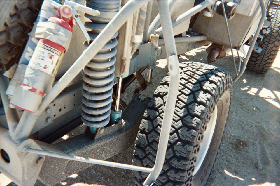 Close-up of an off-road buggy coilover shock, suspension link and knobby tire
