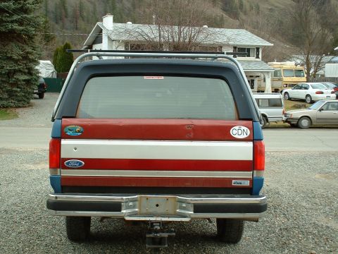 1990 Ford Bronco - This Ford Bronco features a distinctive red, white, and blue stripe pattern on its tailgate.