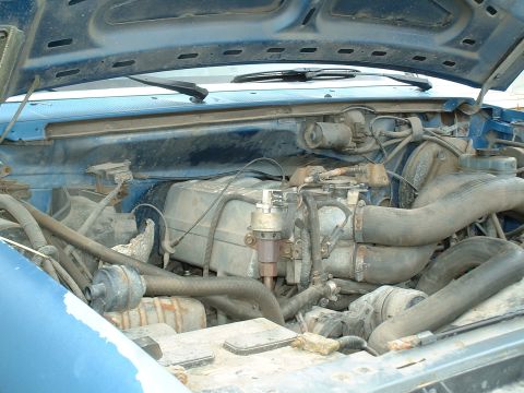1990 Ford Bronco - Engine bay of a 1990 Ford Bronco, showing the engine and surrounding components under the hood.