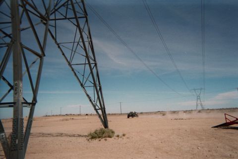 1990 Ford Bronco - Towering steel transmission pylons march across the desert as a distant buggy raises dust beneath the power lines.