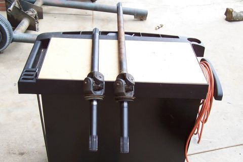 1994 Ford F-150 - Two CV axle shafts are displayed on a workbench, likely for sale or repair.