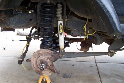 1994 Ford F-150 - Close-up of a vehicle's front suspension and steering system, showing various parts.