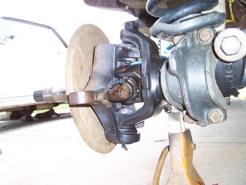 1994 Ford F-150 - The image shows a detailed view of the front axle and suspension system of a vehicle, with a focus on the brake rotor and universal joint.