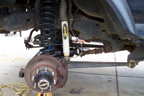1994 Ford F-150 - Close-up view of the front axle and suspension system of a 1994 Ford F-150, highlighting the brake assembly and shock absorber.