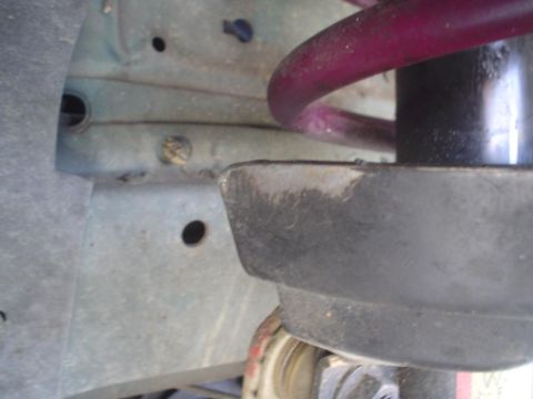 1993 Ford Taurus - A close-up view of the suspension system, focusing on the spring and strut mount.