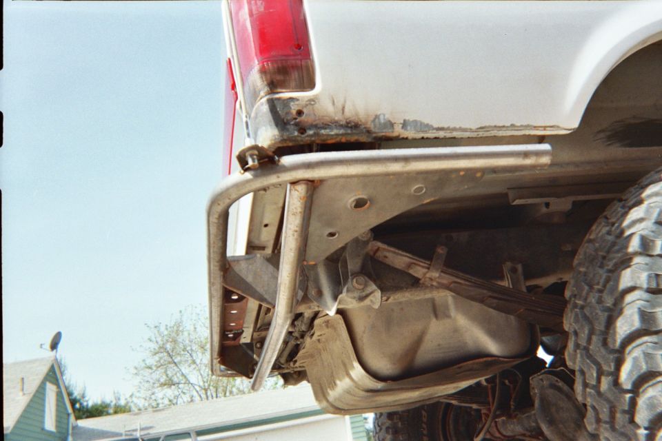 Close-up of a rear tube bumper and undercarriage on a white lifted truck