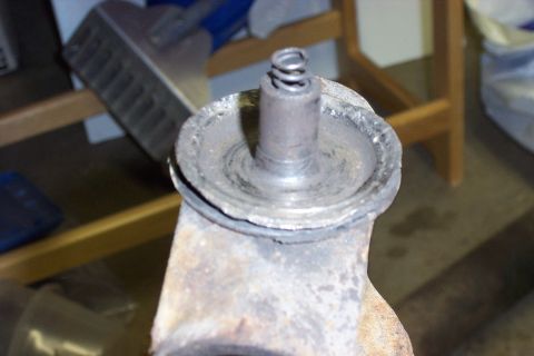 1990 Ford Bronco - Worn U-joint assembly with visible spring and metal parts, likely needing replacement.