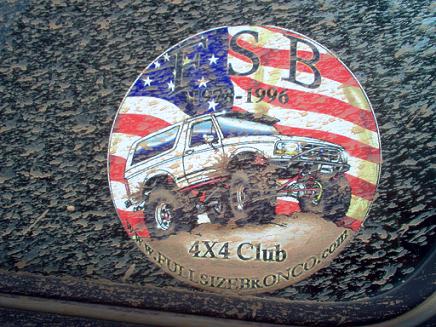 1988 Ford Bronco - A sticker a lifted Bronco is affixed to a mud-covered surface.