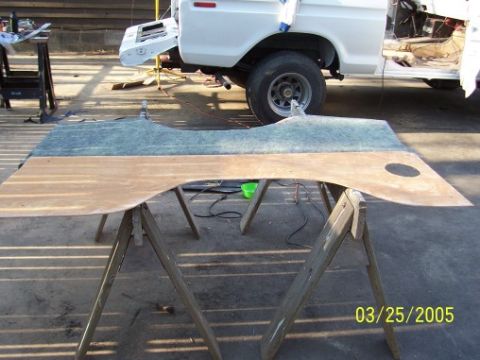 1979 Ford Bronco - A vehicle interior panel rests on sawhorses, with a white truck undergoing work in the background. The date 03/25/2005 is visible.