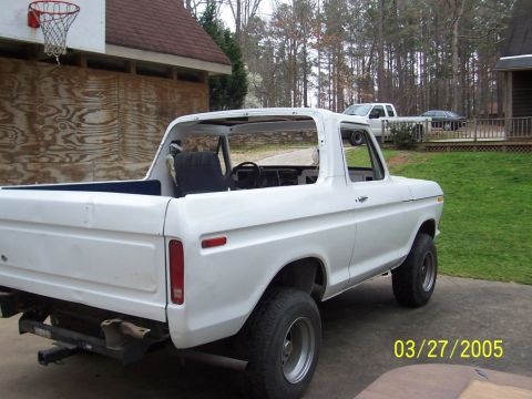 1979 Ford Bronco - A white Ford Bronco, likely from the late 1970s, is shown with its top removed, parked in a driveway.