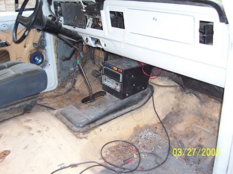 1979 Ford Bronco - The interior of a 1979 Ford Bronco shows a worn seat, exposed wiring, and a floor-mounted shifter, indicating it is undergoing restoration.