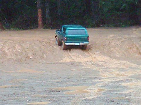 1978 Ford Bronco - A green 1978 Ford Bronco navigates a muddy off-road course.