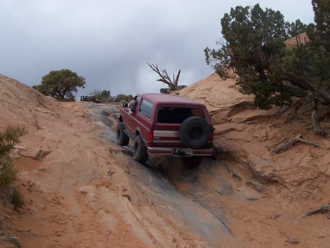 1991 Ford Bronco - 1991 Ford Bronco tackling a challenging off-road trail during an event.