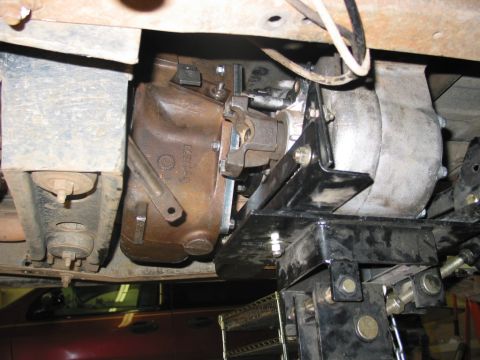 1981 Ford Bronco - The transfer case of a vehicle is shown from below, mounted on a jack for service.