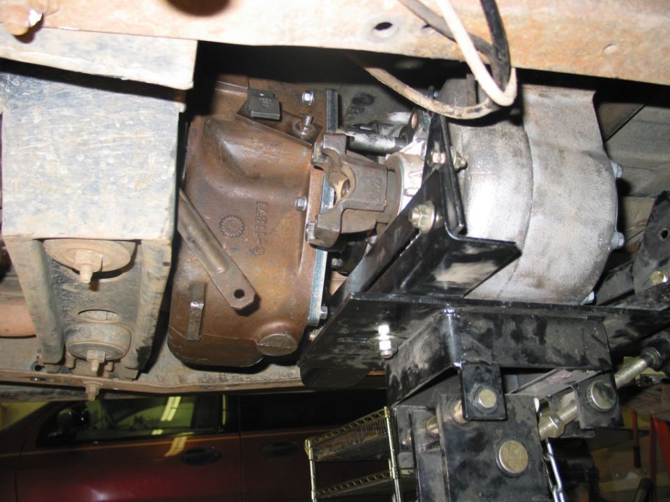 Underside view of transmission with black cross-member mount and cast housing marked 6-11871