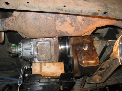 1981 Ford Bronco - Underside view of vehicle drivetrain components, possibly a transfer case, being worked on.