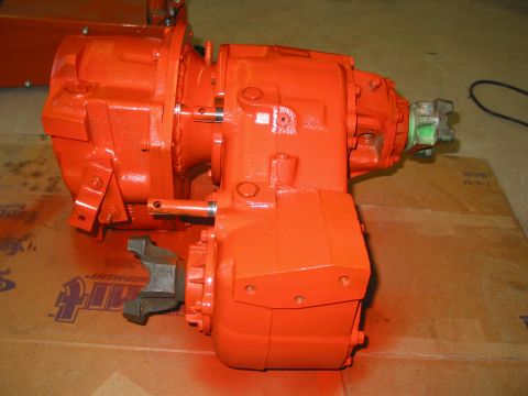 1981 Ford Bronco - Orange transfer case with metal yoke attached to output shaft, resting on cardboard.